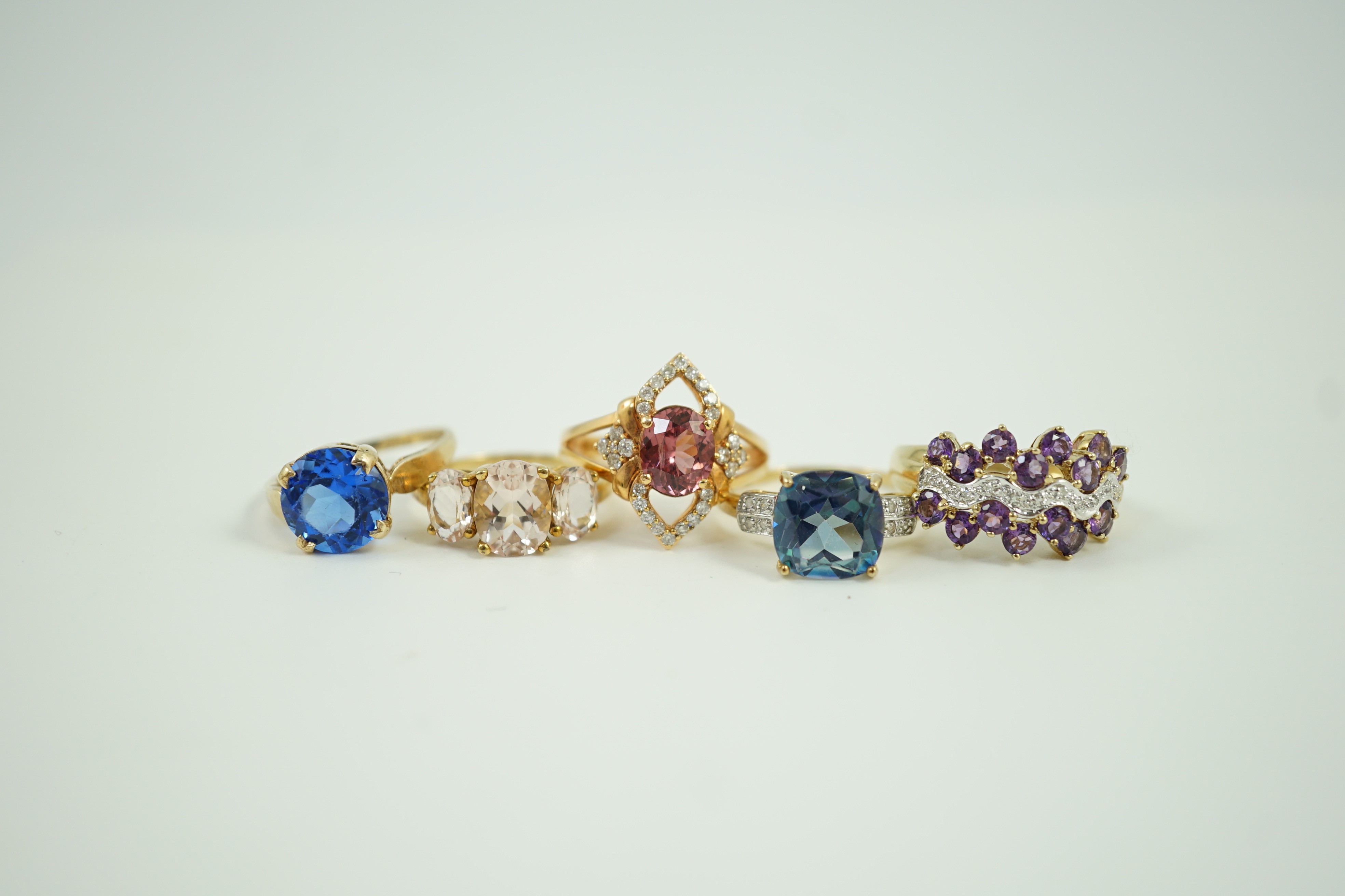 Four assorted modern 9ct gold and gem set rings and a similar 9k gem set ring, gross weight 16 grams.